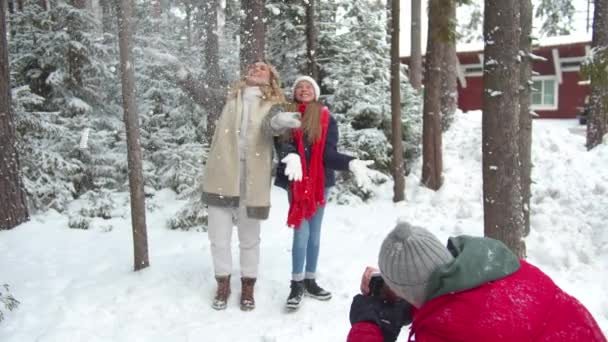 Ο μπαμπάς φωτογραφίζει τη μαμά και την κόρη να παίζουν με το χιόνι. — Αρχείο Βίντεο