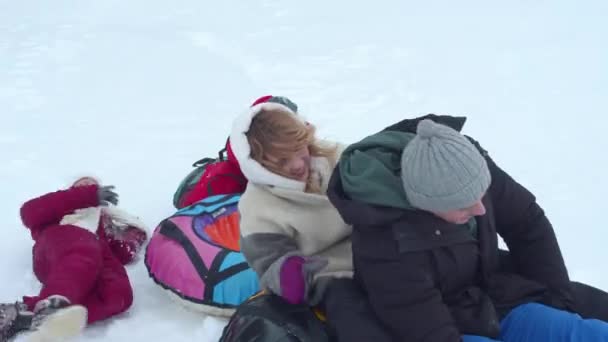 Familjen vältrar sig i snön och har roligt — Stockvideo