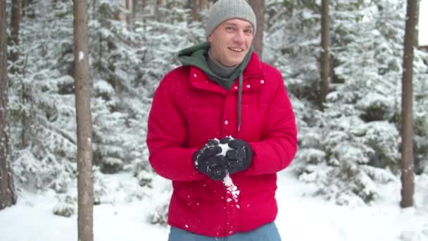 Man in winterhandschoenen beeldhouwt een sneeuwbal. Middelmatig schot — Stockvideo