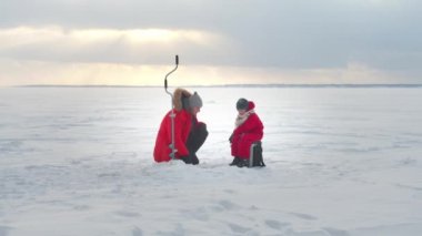 Baba ve oğul kışın balık tutuyorlar. Düşük ihtimal