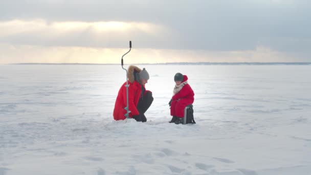 Pai e filho estão pescando no inverno. Tiro longo — Vídeo de Stock