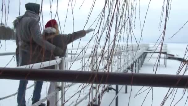 Un par de caminatas por el muelle en el lago congelado . — Vídeos de Stock