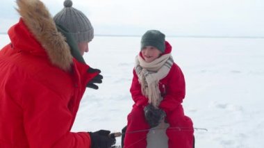 Baba oğluna oltayı nasıl kullanacağını anlatıyor.