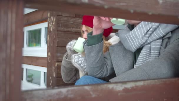 Kvinna chattar med vännen och dricker te på verandan — Stockvideo