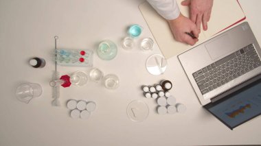 Kimyager bir defter açar ve bir özet yazar.