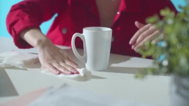 Kadın bardaktan akan suyu siler.