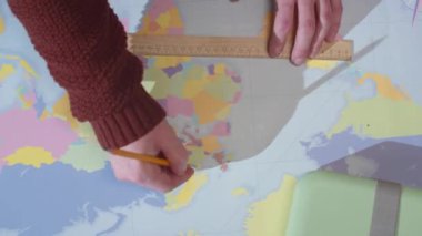 Bir adam dünya haritasındaki bir kalemi sildi.