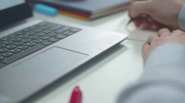 İşçi bir not yazar ve dizüstü bilgisayara yazar. Kaydırma