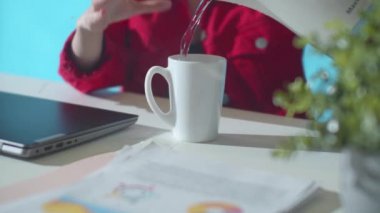 Ofis çalışanı bardaktan su döker. Kapat.