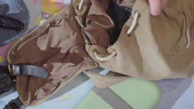 Bir gezgin yürüyüş yaparken sırt çantasını toplar. Üst görünüm