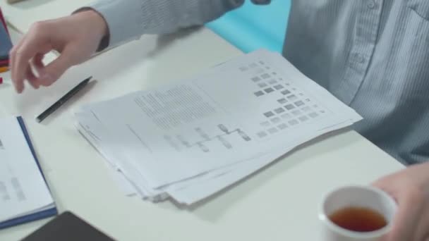 Trabalhador de escritório coloca documentos para baixo e bebe chá — Vídeo de Stock