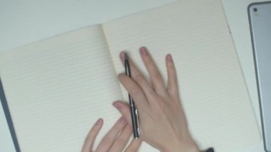 Bir öğrenci deftere yazar. Üst görünüm