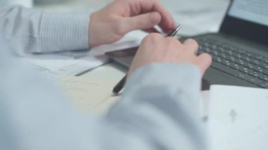 Bir adam dizüstü bilgisayarda çalışıyor ve rapor veriyor. Evrak işleri.