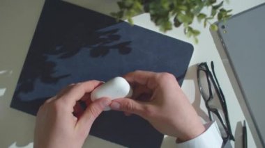 Adam bir kutu kablosuz kulaklık açar ve onları takar.