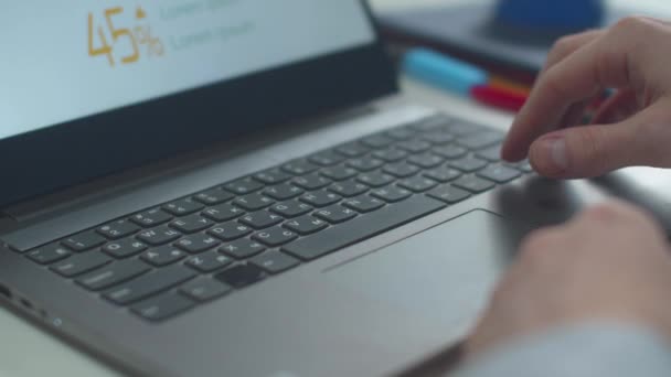 Een man gebruikt een laptop en werkt met documenten — Stockvideo