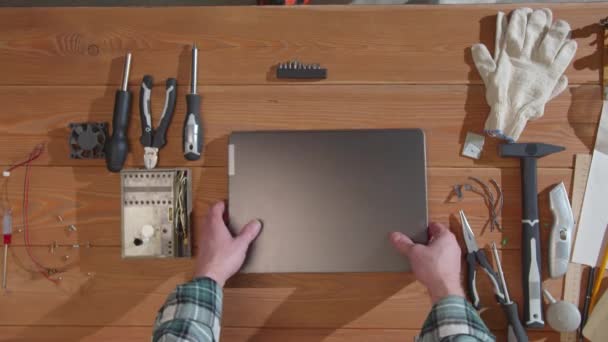 Ремонтник вивчає ноутбук і намагається його увімкнути — стокове відео