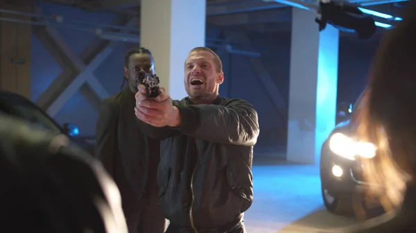 A man during a deal in a parking lot pulls a gun — Stock Photo, Image