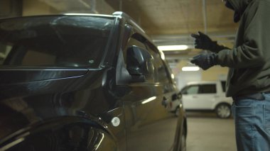 Hacker otoparkta araba açmak için bir cihaz kullanıyor.