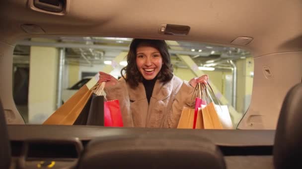 Το κορίτσι χαμογελάει και κρατάει πακέτα με αγορές στα χέρια της — Αρχείο Βίντεο