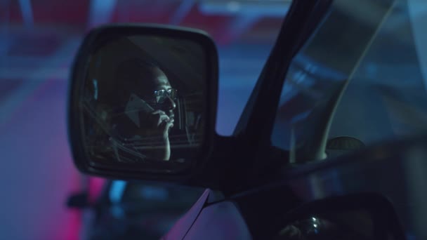 Un uomo sta parlando al telefono. Auto vista laterale specchio — Video Stock