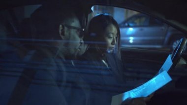 Kadın ve erkek arabada iş tartışır. Orta boy yakın çekim