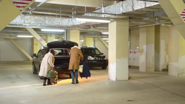 Homme et femme pressés empilent leurs bagages dans une voiture — Video