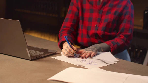 Женщина-хипстер работает с ноутбуком и рисует эскизы — стоковое фото