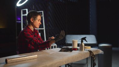 Dövme ustası siyah lateks eldiven giyer.