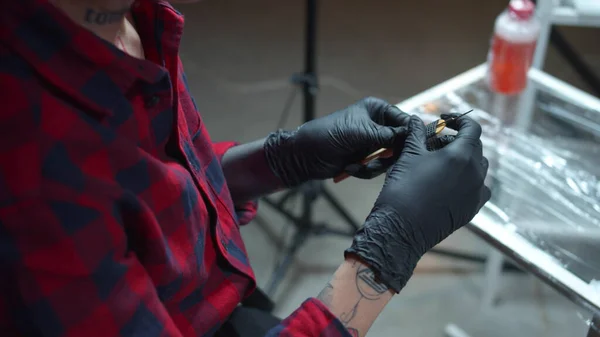 Flicka med piercing förbereder en nål för en tatuering — Stockfoto