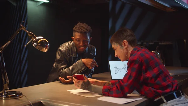 Bir adam telefonunu kullanarak bir dövme seçer. Orta boy.