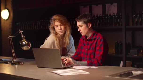 Girl with a tattoo artist will choose sketches on a laptop — Stock Video