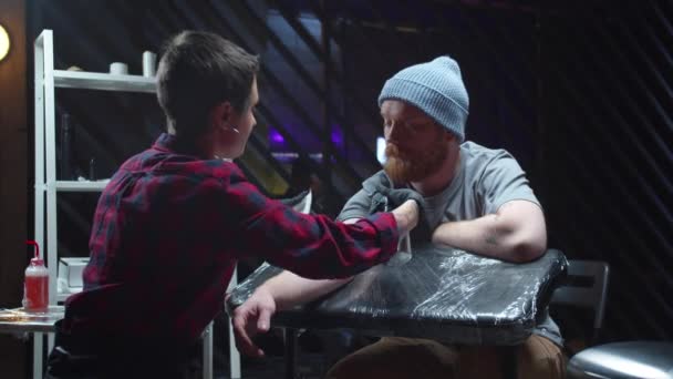 Seniman Tato menggosok tangan seorang pria dengan antiseptik — Stok Video