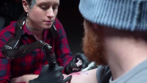 Punk meisje voedt een tatoeage op arm van haar vriend — Stockvideo