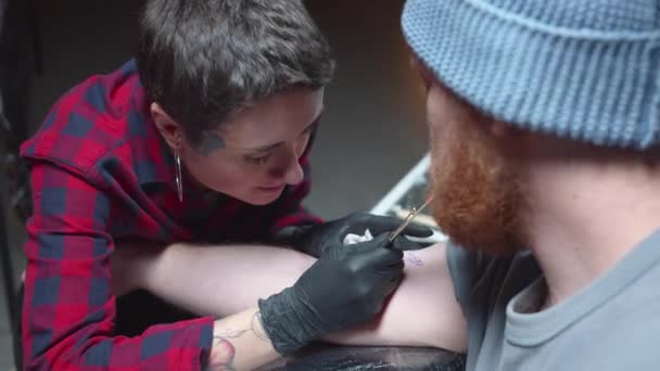 La muchacha rellena el tatuaje y unta la piel con la crema — Vídeos de Stock