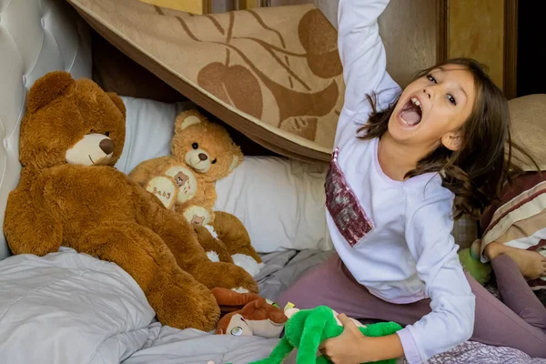 Kislány játszik az ágyban — Stock Fotó