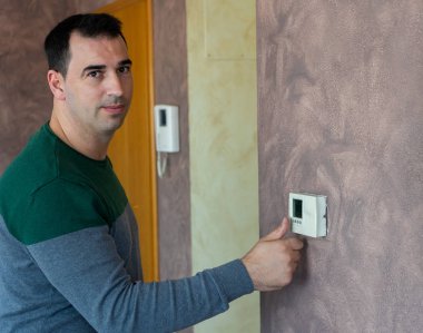 Adam ısıtmayı çalıştırıyor.