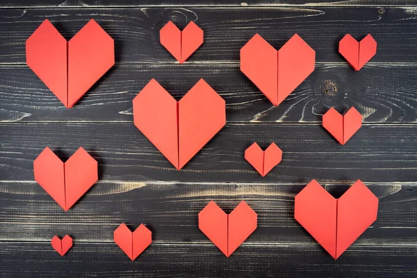 Красные Оригами Сердца Разных Размеров Композиции Выветриваемом Черном Деревянном Фоне — стоковое фото