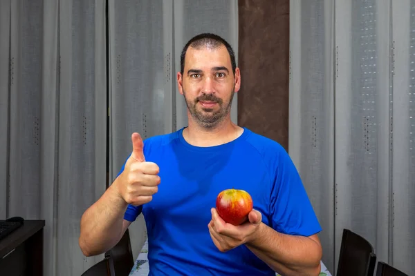 留着胡子 留着短发 蓝色T恤 拿着一个苹果的男人 健康生活概念 — 图库照片
