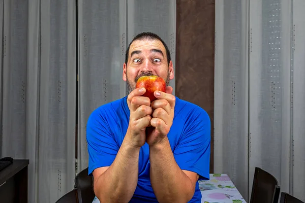 留着胡子 留着短发 蓝色T恤 拿着一个苹果的男人 健康生活概念 — 图库照片