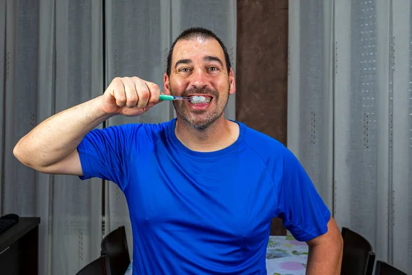 一个留着胡子 留着短发 穿着蓝色衬衫的男人在刷牙 卫生概念 — 图库照片