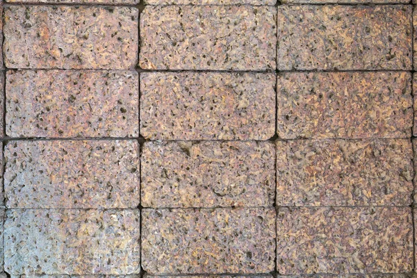 Stone wall of porous volcanic bricks close up rough surface texture