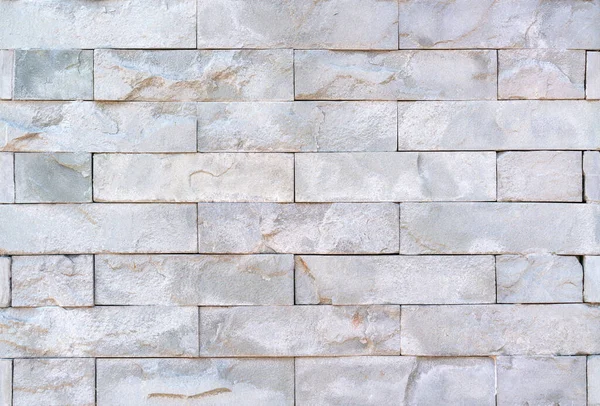 Stone cladding wall made of striped stacked slabs of natural brown rocks, panels for exterior