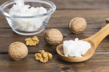 Kozmetik 'te kullanmak için ahşap zemin üzerinde kaşık içinde katı ceviz yağı