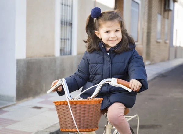 Piccola ragazza sorridente in sella alla moto sulla strada asfaltata in c — Foto Stock