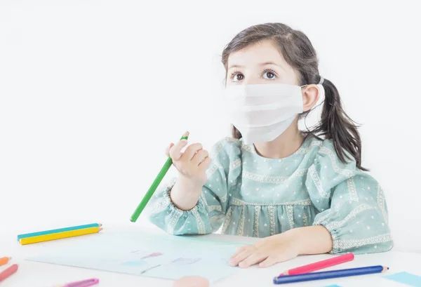 小女孩带着面具在家里或学校学习和画画 Coronavirus Covid — 图库照片