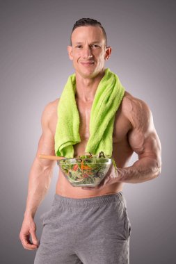 Kaslı adam holding salata