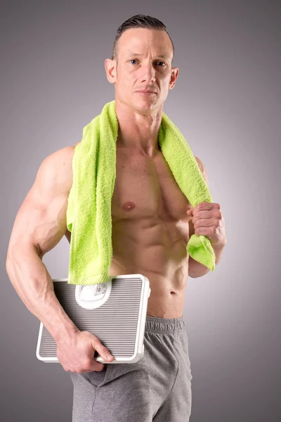 Homem muscular segurando escalas — Fotografia de Stock