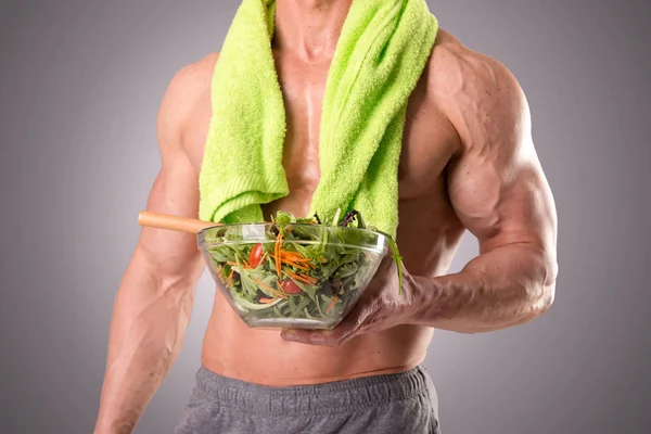 М'язистий чоловік тримає салат — стокове фото