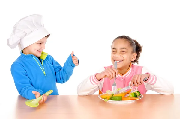 Niño y niña comiendo verduras —  Fotos de Stock