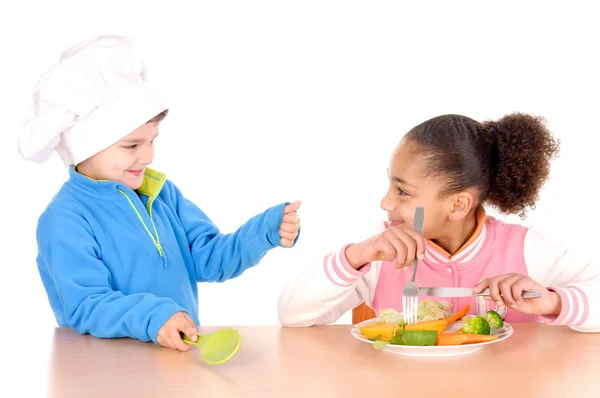Niño y niña comiendo verduras — Foto de Stock